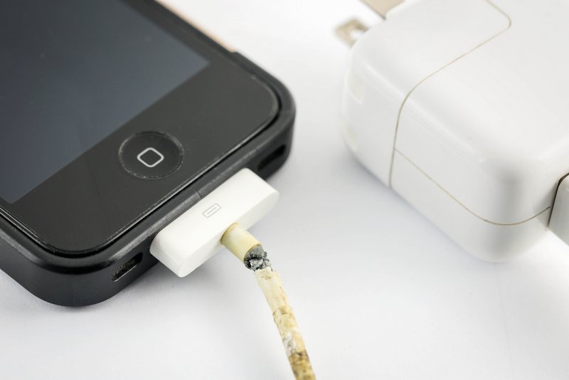 Nakhonratchasima, THAILAND September 17, 2015 : Close up iPhone broken old charger on white background.